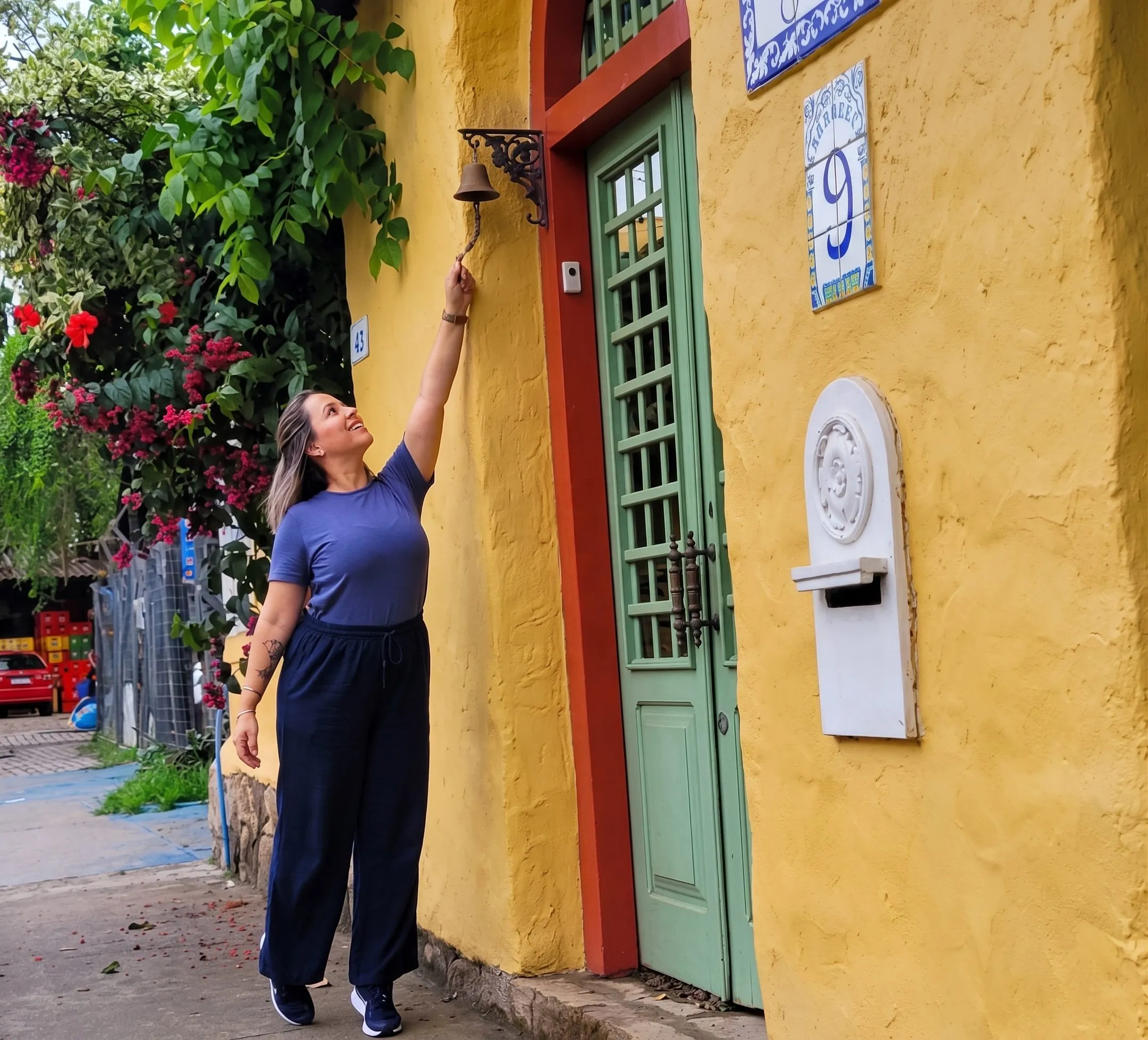 Sabrina em viagem, diante de uma casa colonial amarela